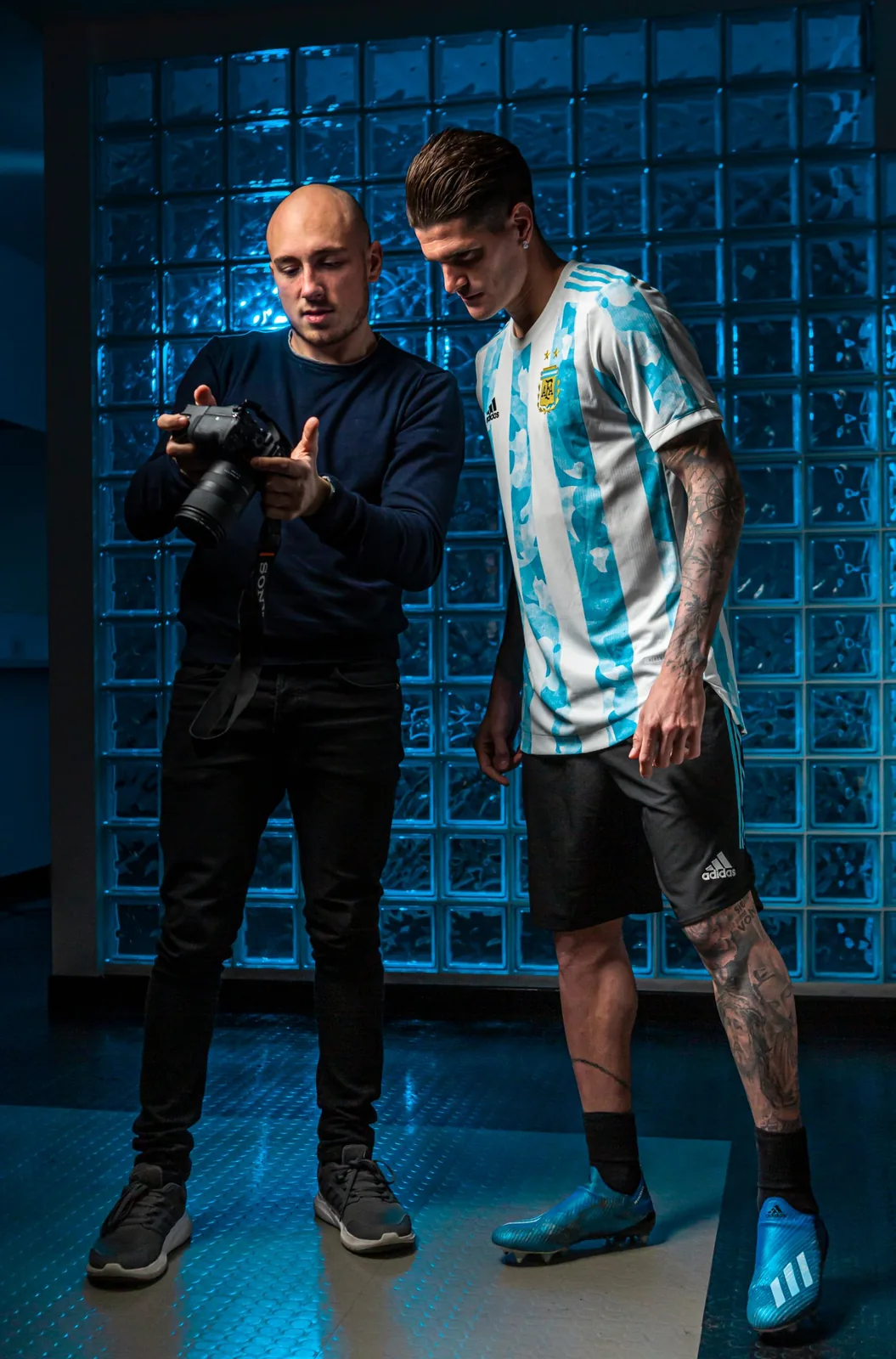 Fotografo mostra la fotocamera a un calciatore in maglia Argentina durante un servizio