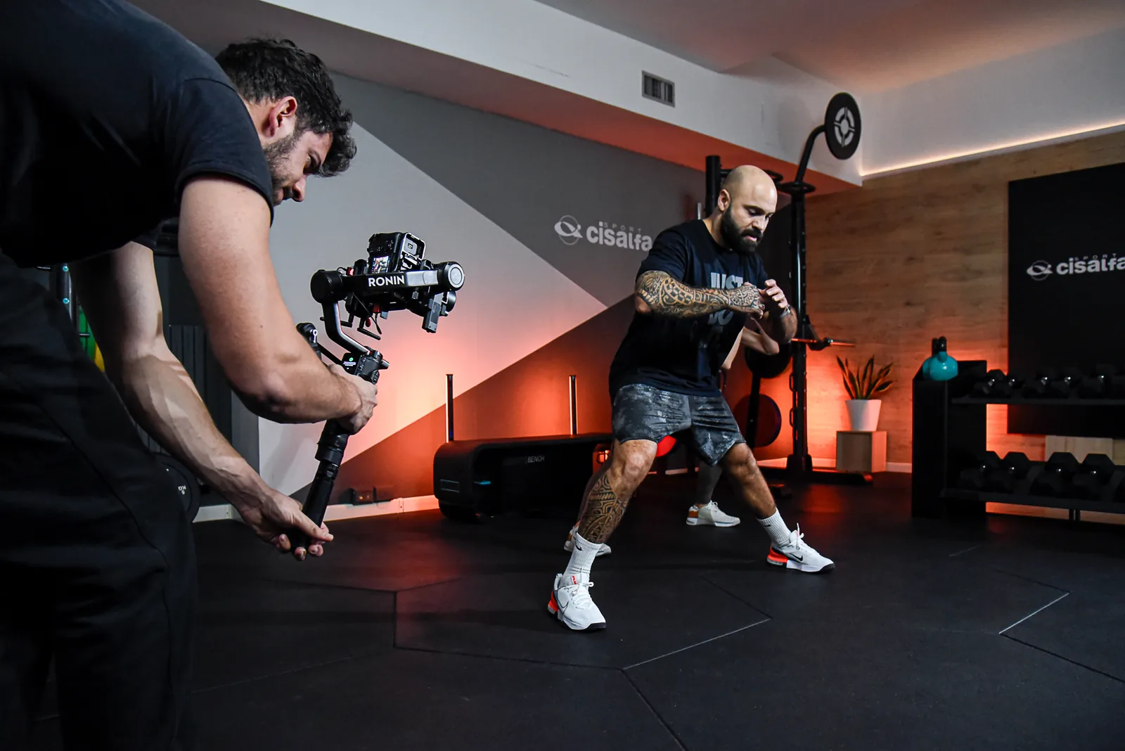 Operatore con gimbal Ronin durante le riprese di un allenamento in palestra